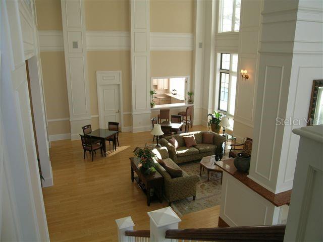 An elevated view of a living room and dining area with high ceilings and hardwood floors — 750 N TAMIAMI TRAIL UNIT 705, SARASOTA, FL