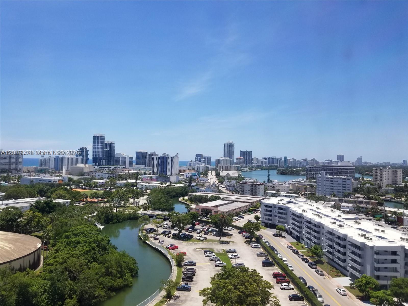 An elevated view shows a city skyline, a winding canal, and a parking lot — 7441 Wayne Ave # 7J, Miami Beach FL 33141, MIAMI BEACH, FL