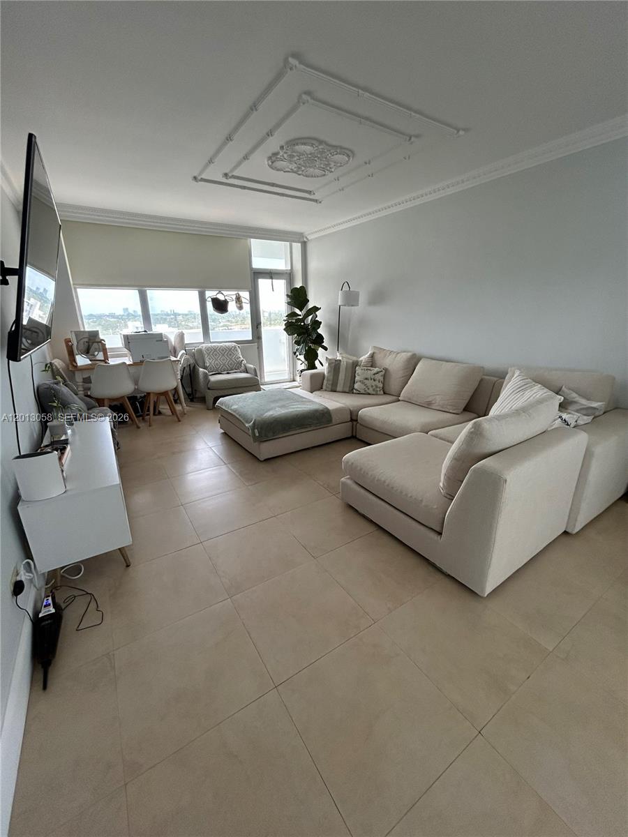 A living room features a large sectional sofa, tile flooring, and a dining area — 7441 Wayne Ave # 7J, Miami Beach FL 33141, MIAMI BEACH, FL