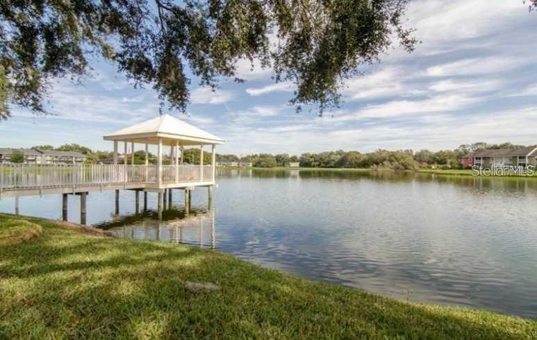 A white gazebo sits at the end of a wooden pier extending into a lake — 803 LAKE HAVEN SQUARE UNIT 202, BRANDON, FL