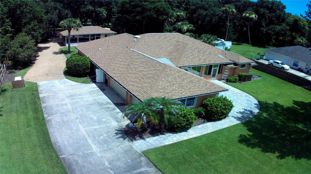 An aerial view shows a single-story house with a shingled roof, driveway, and detached garage — 751 CALLE GRANDE STREET, ORMOND BEACH, FL