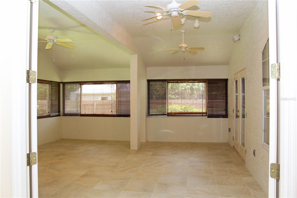A sunroom with tile flooring, two ceiling fans, and windows covered by bamboo blinds — 751 CALLE GRANDE STREET, ORMOND BEACH, FL