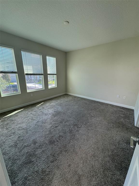 An empty bedroom features gray carpeting, light-colored walls, and three windows with white blinds — 14252 TITLE WAY, WINTER GARDEN, FL