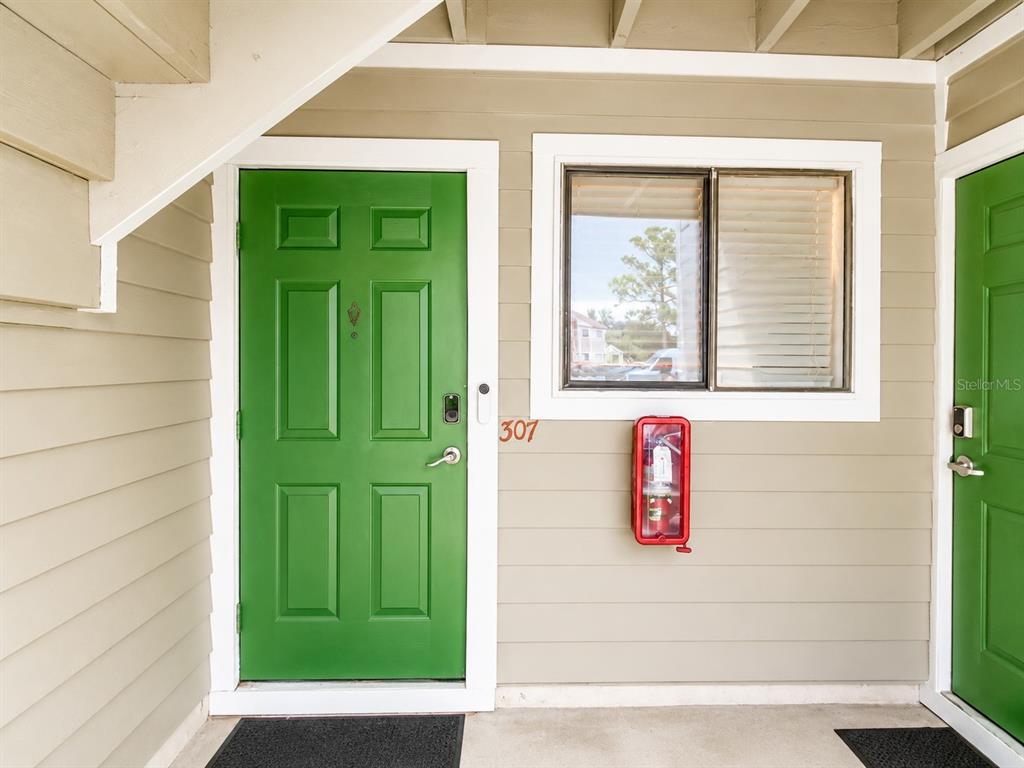 A green front door with the number 307 sits next to a window and fire extinguisher — 7298 ULMERTON ROAD UNIT 307, LARGO, FL