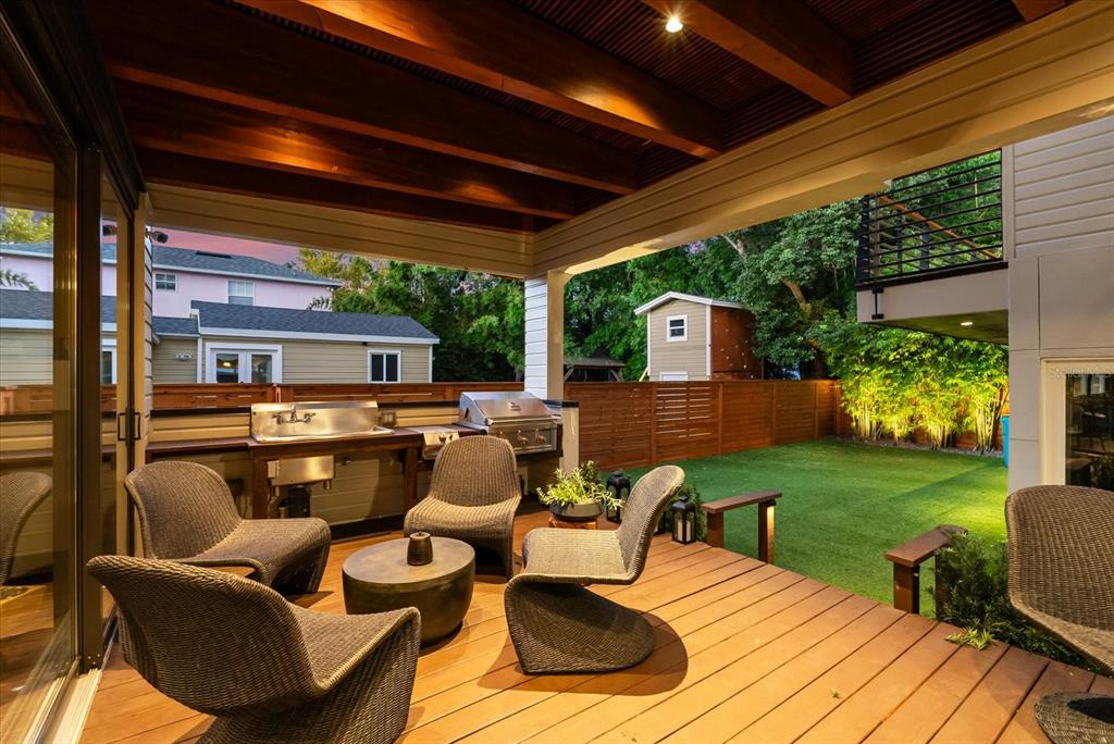 A two-story house with a metal roof and a front porch sits behind a wooden fence — 119 N HYER AVENUE, ORLANDO, FL