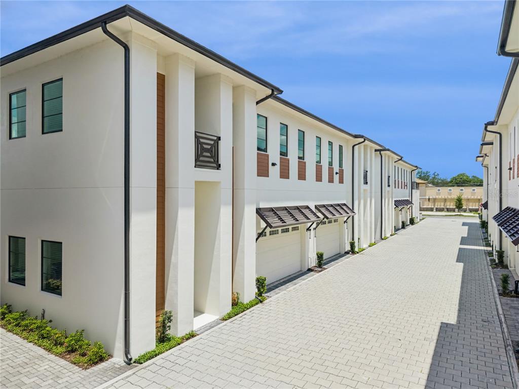 A row of modern white townhouses with attached garages faces a paved alleyway — 512 W SWOOPE AVENUE, WINTER PARK, FL