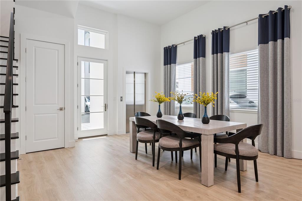 A dining room features a light wood table, dark chairs, and floor-to-ceiling curtains — 512 W SWOOPE AVENUE, WINTER PARK, FL