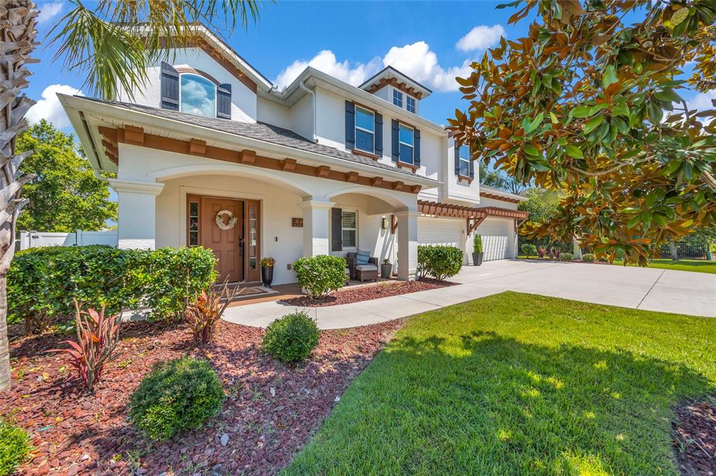 A two-story white house with a brown front door, arched porch, and attached garage — 6835 STONEHEATH LANE, PORT ORANGE, FL