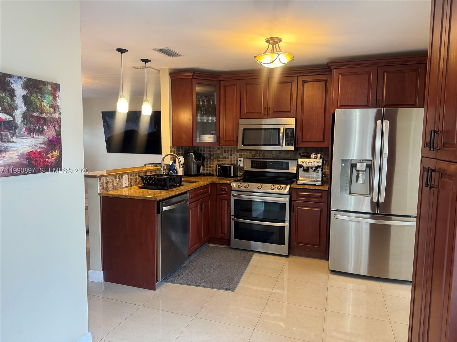 A living room features two dark leather sofas, a stone coffee table, and tile flooring — 1460 NE 30th Ct, Pompano Beach FL 33064, POMPANO BEACH, FL