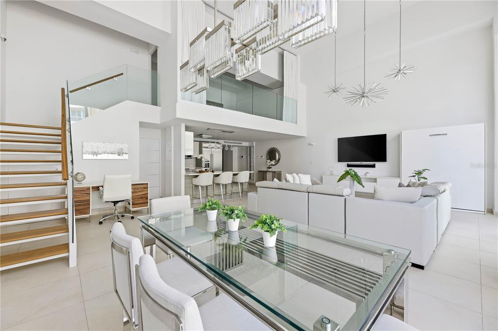 A modern, open-concept living and dining area features high ceilings, a glass table, and stairs — 25 MUNOZ RIVERA AVENUE UNIT 421, SAN JUAN, PR