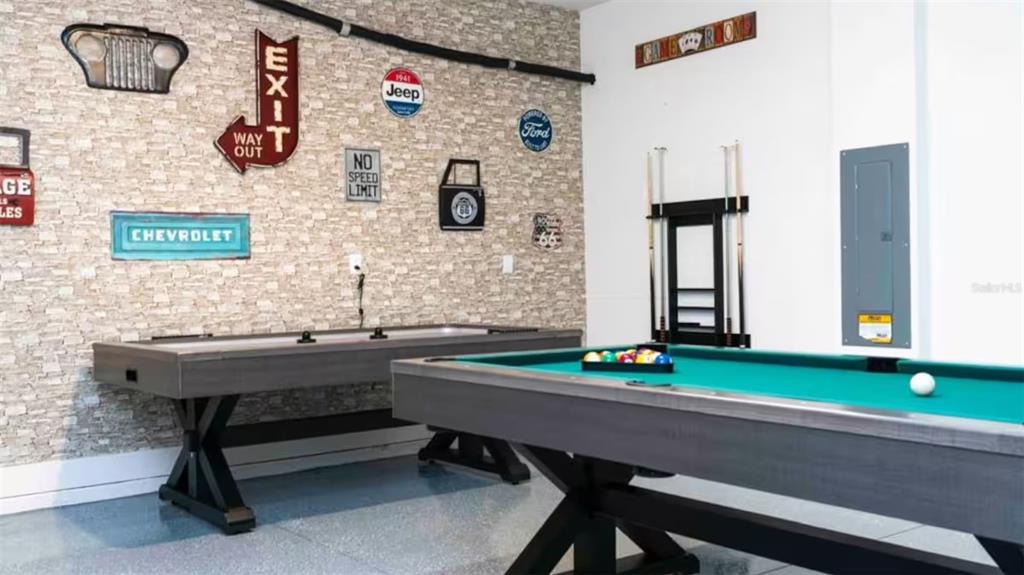 A game room features a pool table, air hockey table, and automotive-themed wall decor — 7958 HAVERHILL WAY, KISSIMMEE, FL