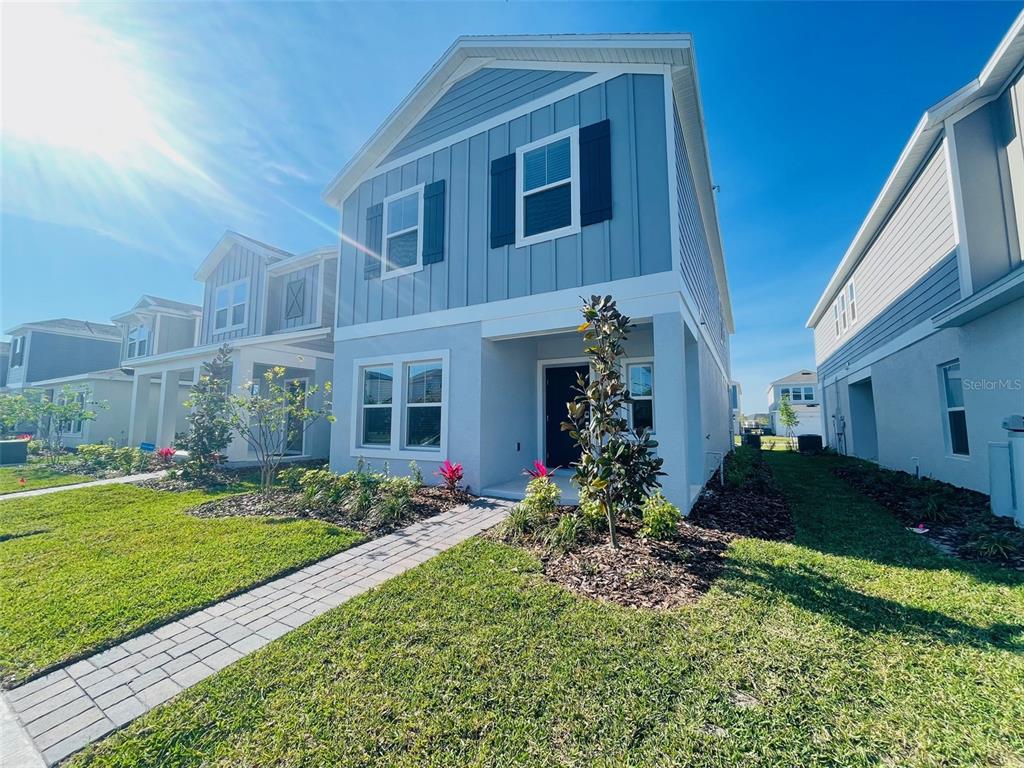 A two-story light blue house with a paved walkway and a small front yard — 6641 WILLOW VIEW AVENUE, ORLANDO, FL