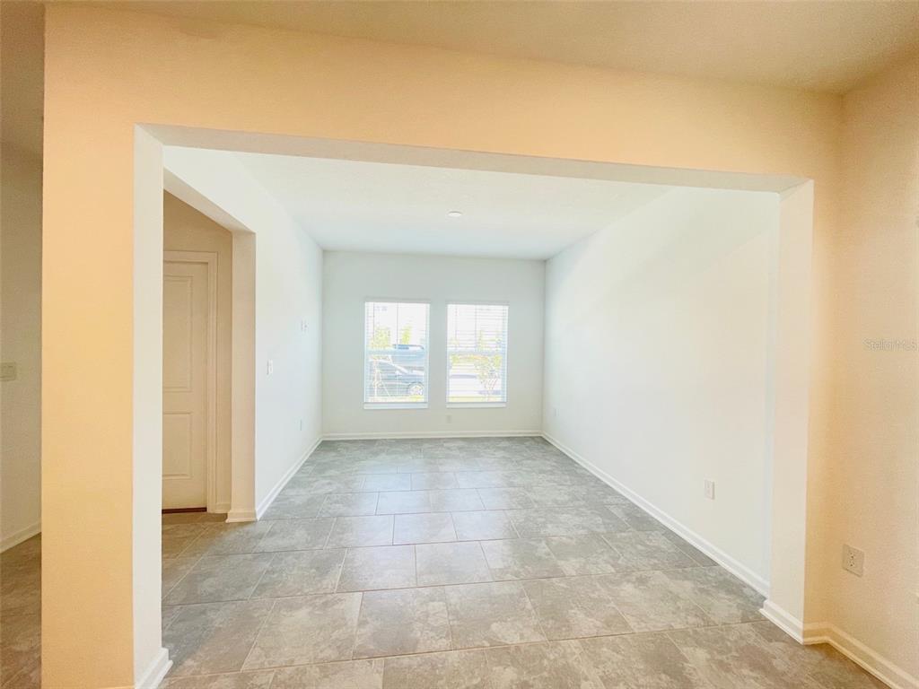 An empty room with light-colored walls, tile flooring, and two windows — 6641 WILLOW VIEW AVENUE, ORLANDO, FL