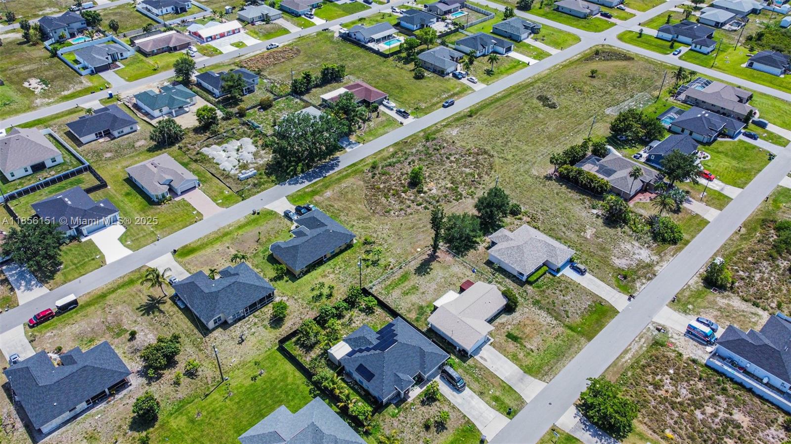 An aerial view shows several single-family homes with driveways and lawns in a suburban neighborhood — 309 NW 4th Ter, Cape Coral FL 33993, CAPE CORAL, FL