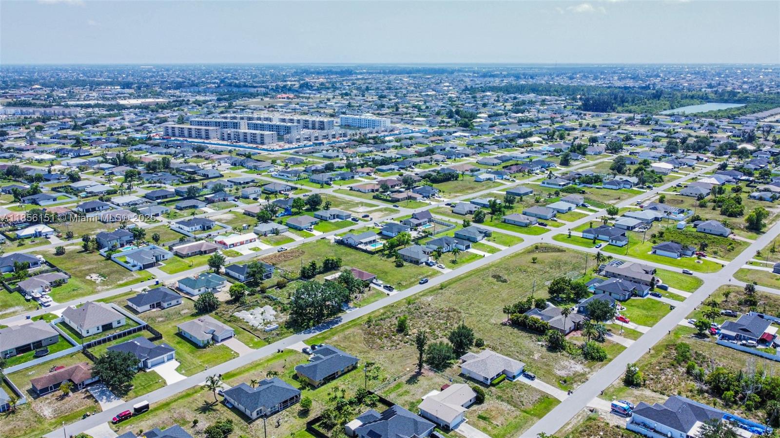 An aerial view shows a suburban neighborhood with single-family homes and a large apartment complex — 309 NW 4th Ter, Cape Coral FL 33993, CAPE CORAL, FL