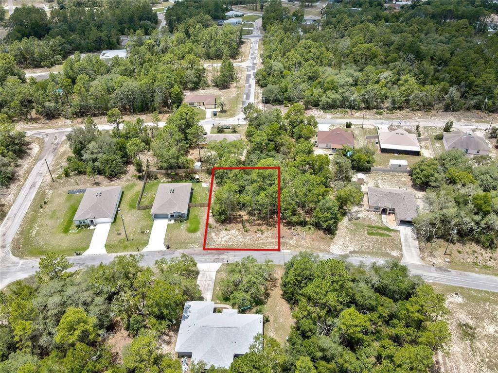 An aerial view shows a vacant, wooded residential lot outlined in red between two houses — 9640 N SAN JOSE WAY, CITRUS SPRINGS, FL