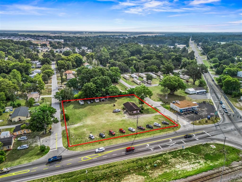 An aerial view shows a corner lot with a small building and parked cars — 6137 SE HAMES ROAD, BELLEVIEW, FL