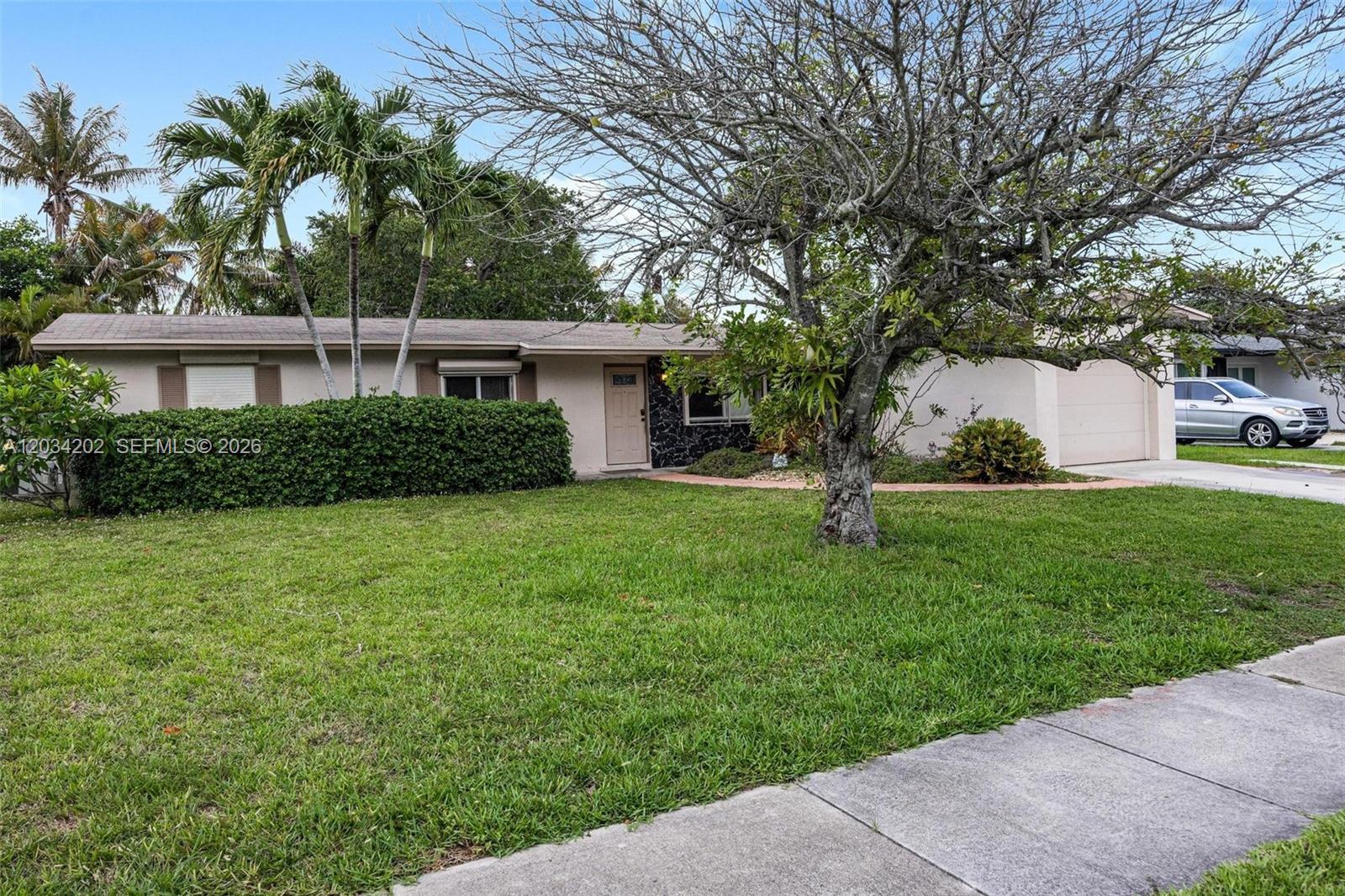 A single-story house with a lawn, a large tree, and a driveway with a car — 8771 SW 200th Ter, Cutler Bay FL 33189, CUTLER BAY, FL