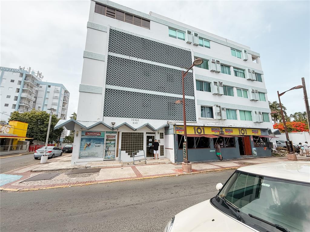 A multi-story building with a patterned facade, ground-floor commercial spaces, and a street-level sidewalk — . BLASCOCHEA UNIT 311, CAROLINA, PR