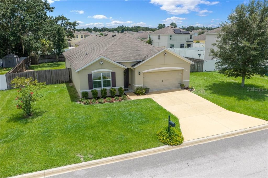 An aerial view of a single-story suburban house with a tan exterior and two-car garage — 3063 NE 42ND ROAD, OCALA, FL