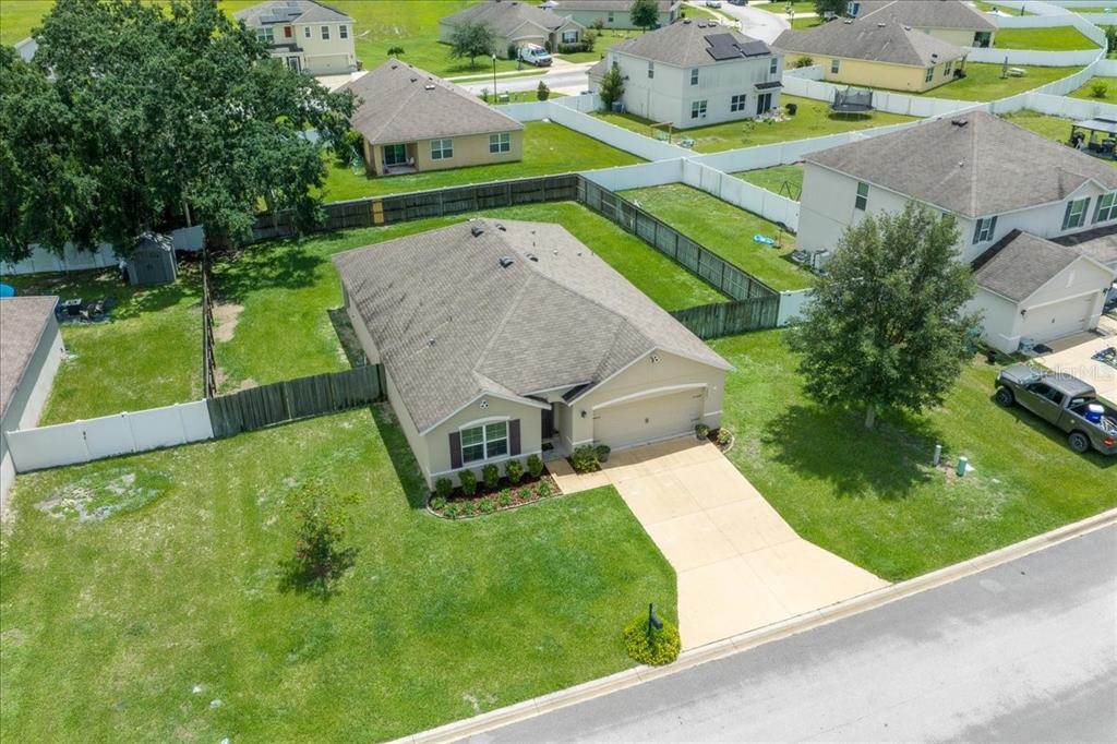 An aerial view shows a single-story suburban house with a tan exterior and gray roof — 3063 NE 42ND ROAD, OCALA, FL