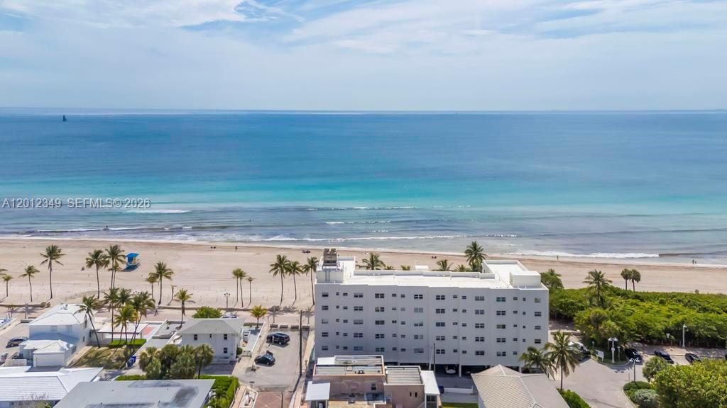 An aerial view shows a white multi-story building situated on a beach by the ocean — 901 S Surf Rd # 404, Hollywood FL 33019, HOLLYWOOD, FL