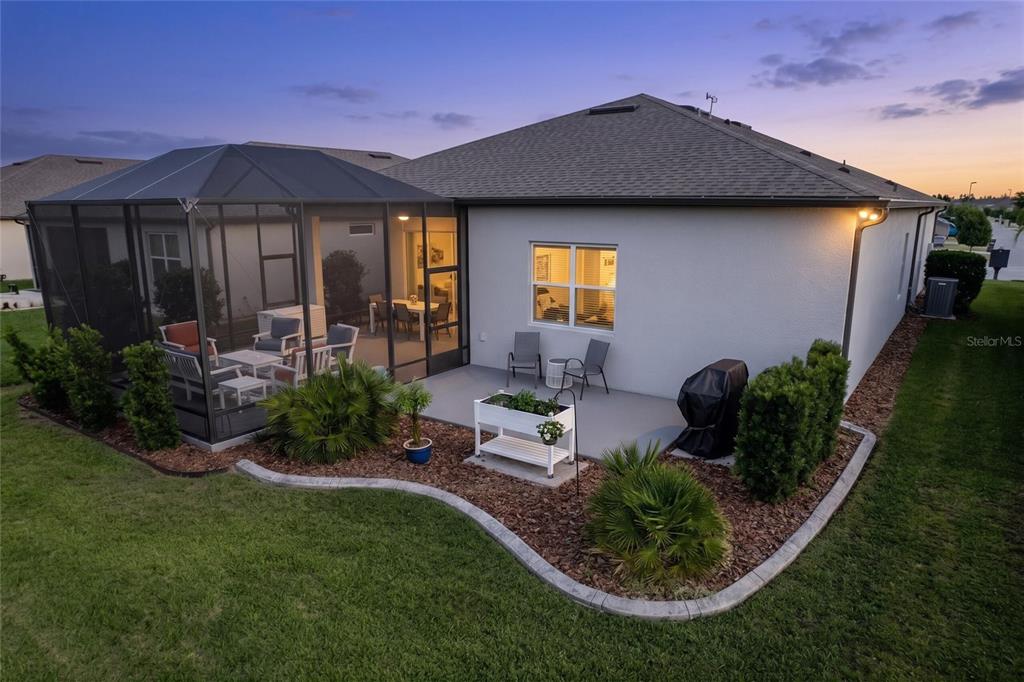 An aerial view of a house exterior featuring a screened-in patio and a landscaped backyard — 9336 SW 56TH LOOP, OCALA, FL