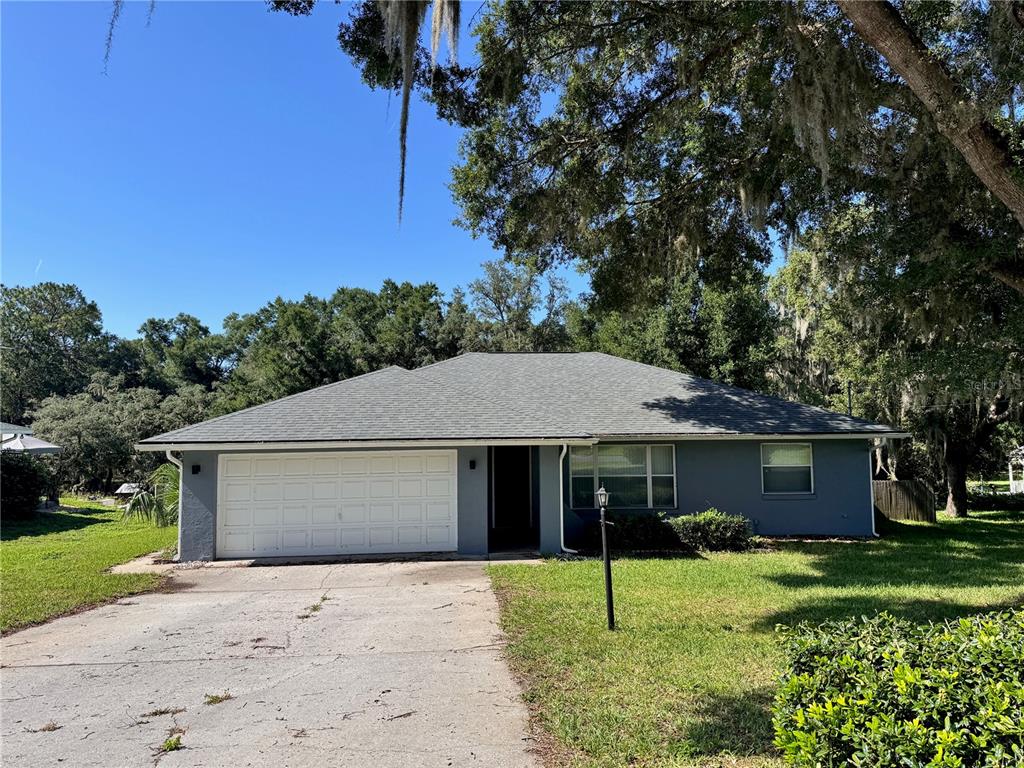 A single-story gray house with a white garage door and a concrete driveway — 8114 E DECATUR COURT, FLORAL CITY, FL