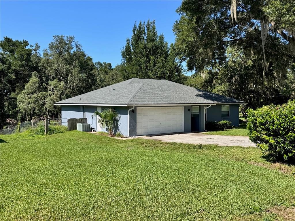 A blue detached garage with a gray hip roof sits on a grassy lot — 8114 E DECATUR COURT, FLORAL CITY, FL