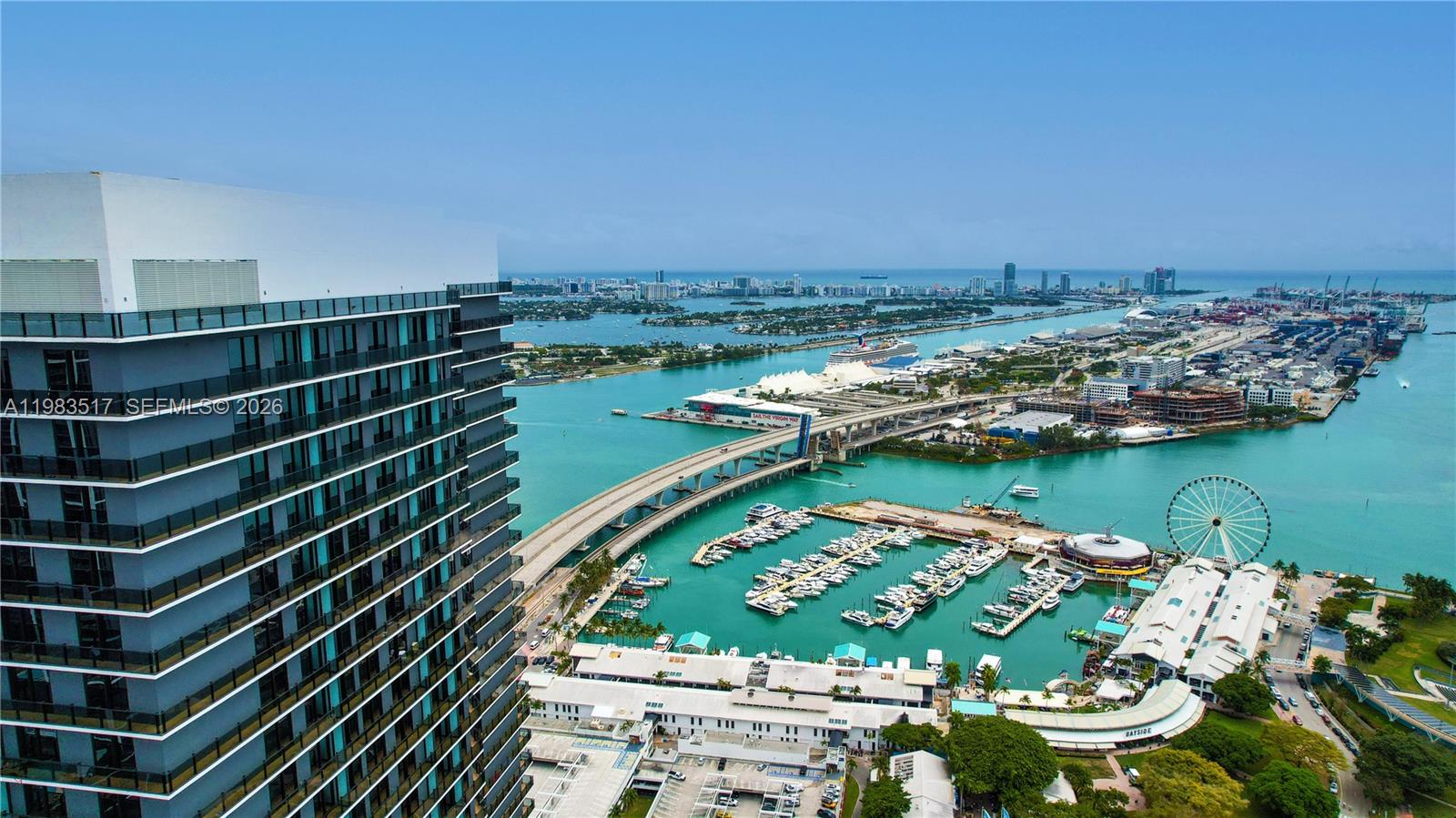 An aerial view shows a tall modern building overlooking a marina, bridge, and city skyline — 398 NE 5th St # 3516, Miami FL 33132, MIAMI, FL