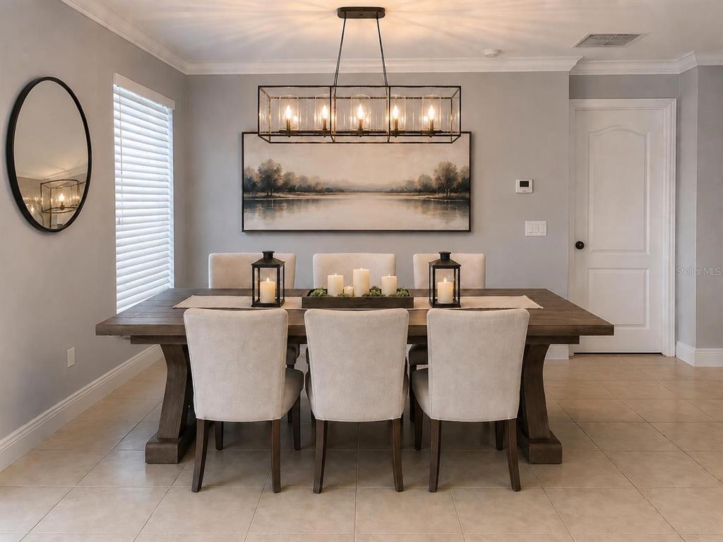 A dining room features a wooden table, six upholstered chairs, a rectangular chandelier, and landscape art — 3913 PEMBERLY, ST CLOUD, FL