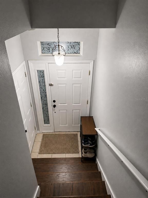 A view from the top of a staircase looking down at a home entryway — 3913 PEMBERLY, ST CLOUD, FL