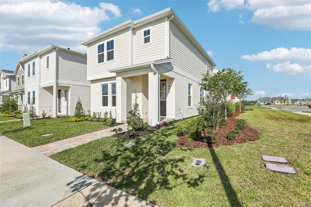 A two-story house with light-colored siding and a paved walkway leading to the front entrance — 1950 EDUCATION STREET, ST CLOUD, FL