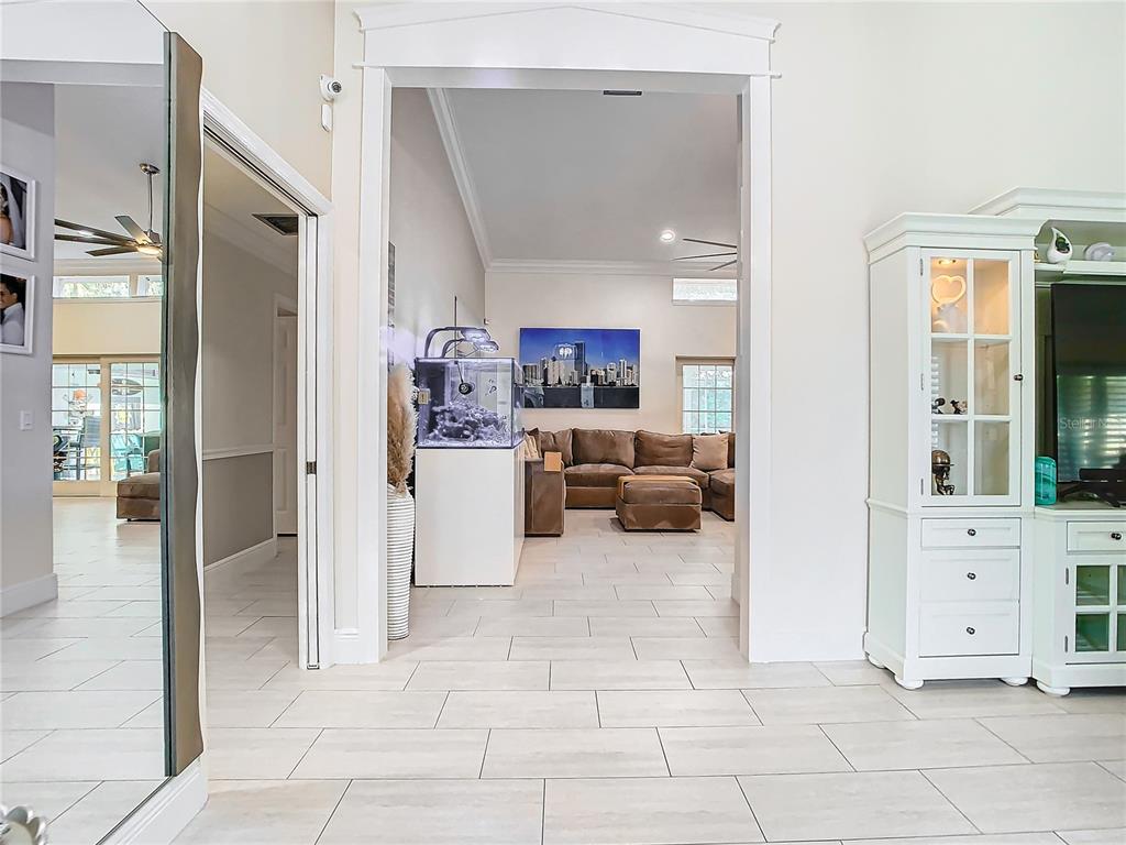 A view through a doorway into a living room with tile floors and an aquarium — 8707 FERNWICKE COURT, ORLANDO, FL
