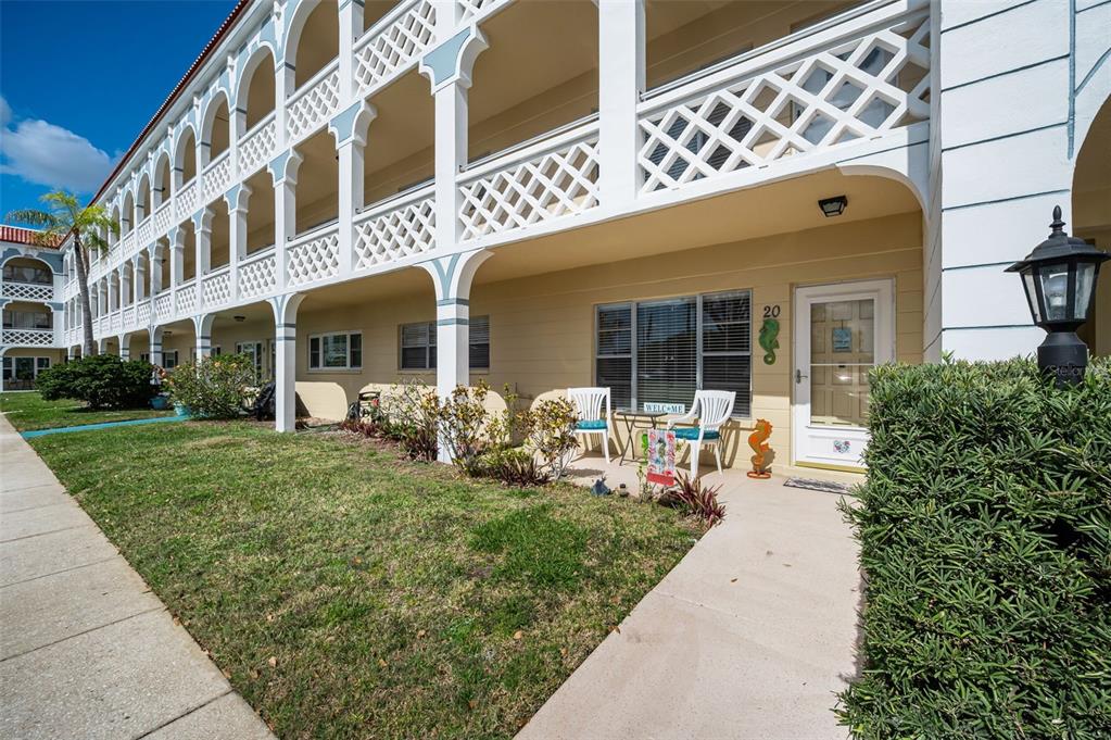 A multi-story apartment building with a white lattice balcony and a ground-level patio entrance — 2404 FLORENTINE WAY UNIT 20, CLEARWATER, FL
