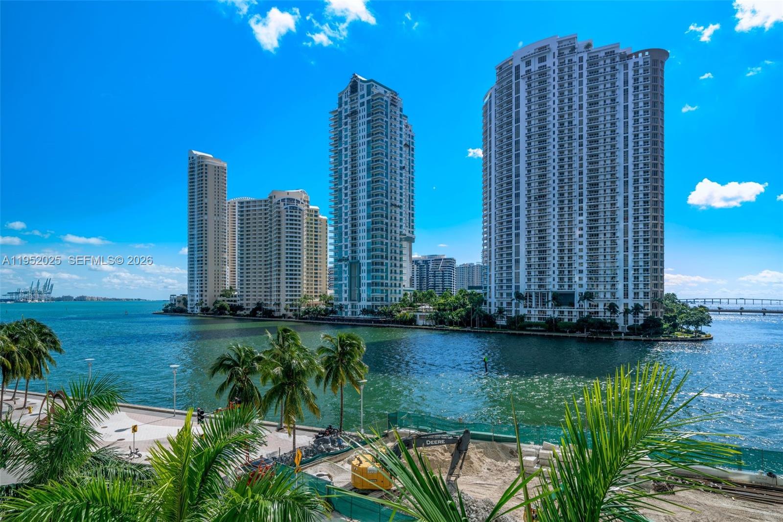 A view of high-rise apartment buildings across a bay with construction equipment in the foreground — 300 S BISCAYNE BLVD # 410, Miami FL 33131, MIAMI, FL