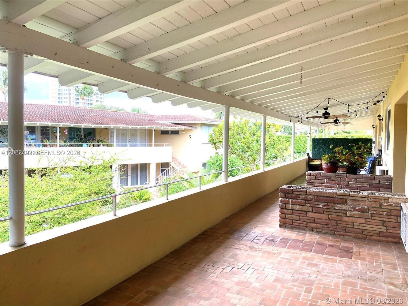 A covered outdoor balcony features brick flooring, a stone planter, and a white ceiling — 30 Park Dr # 16, Bal Harbour FL 33154, BAL HARBOUR, FL