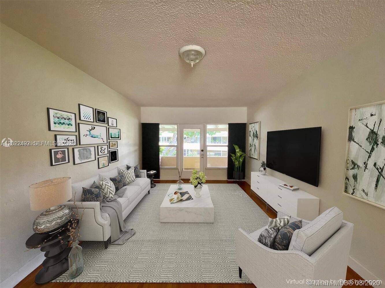 This living room features a white sofa, a marble coffee table, and a wall-mounted television — 30 Park Dr # 16, Bal Harbour FL 33154, BAL HARBOUR, FL
