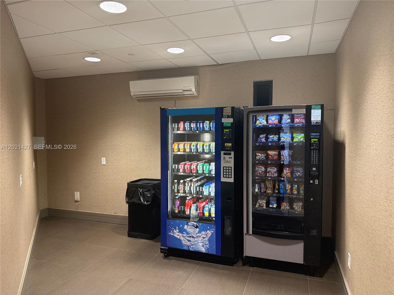A small room contains two vending machines and a trash can against a beige wall — 290 NW 165th St # 700, Miami FL 33169, MIAMI, FL