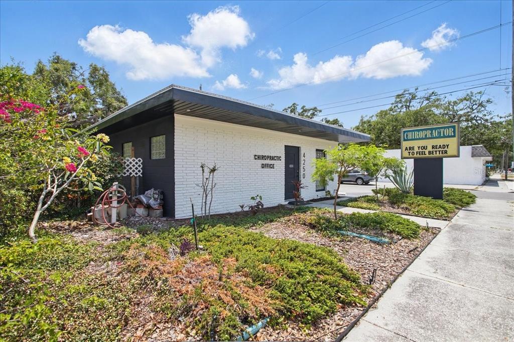 A white brick chiropractic office building with a flat roof sits next to a sidewalk — 4250 W BAY TO BAY BOULEVARD, TAMPA, FL