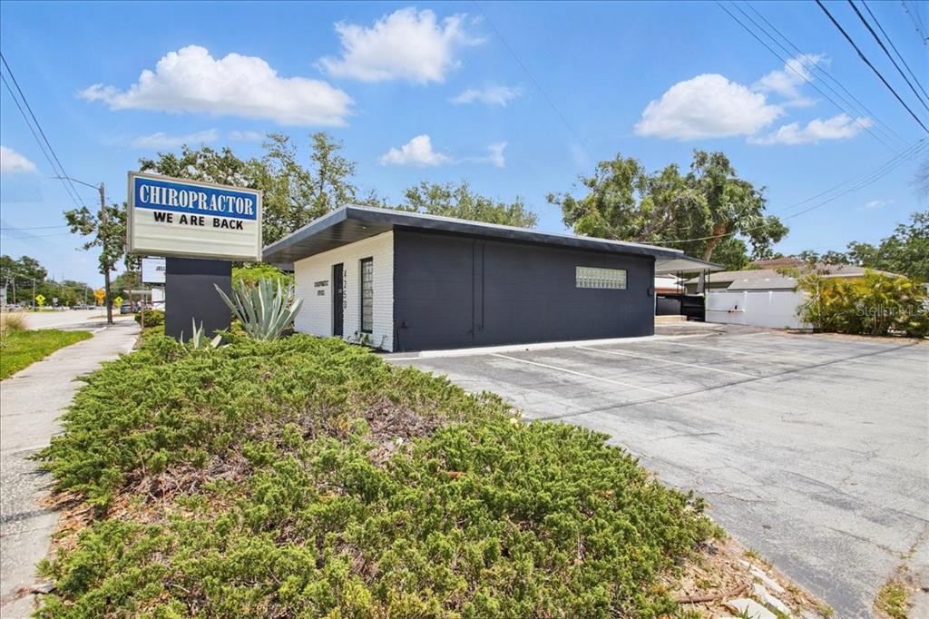 A single-story commercial building with a black exterior and a chiropractor sign in the front — 4250 W BAY TO BAY BOULEVARD, TAMPA, FL