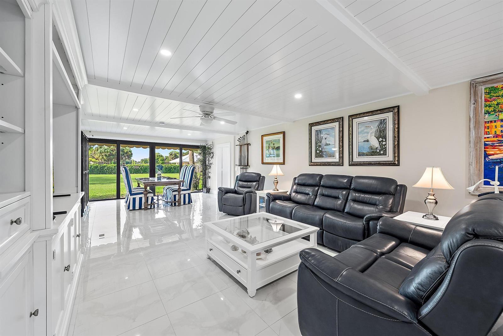 A living room with white tile floors, a white plank ceiling, and dark leather furniture — 3693 Quail Ridge Drive # B, Boynton Beach FL 33436, BOYNTON BEACH, FL
