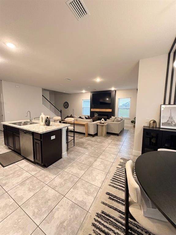An open-concept kitchen with a dark island overlooks a living room with a fireplace — 13058 OGDEN GLADE ROAD, DADE CITY, FL