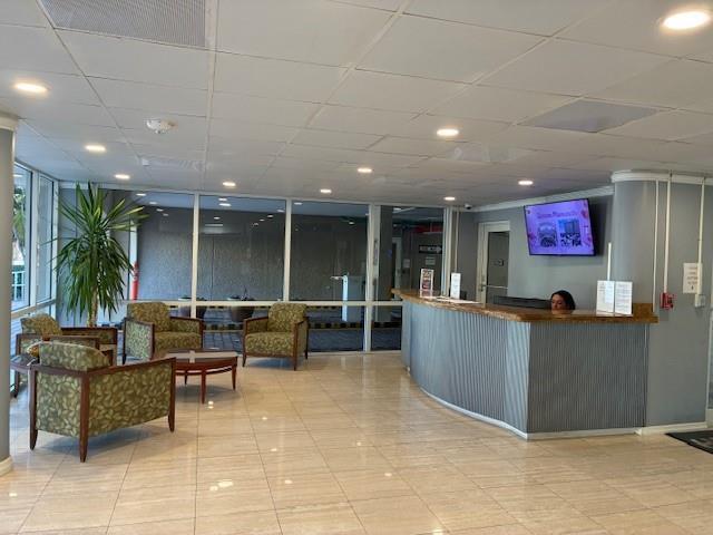 A lobby features a reception desk, patterned armchairs, and large windows with exterior views — 133 N Pompano Beach Boulevard # 209, Pompano Beach FL 33062, POMPANO BEACH, FL
