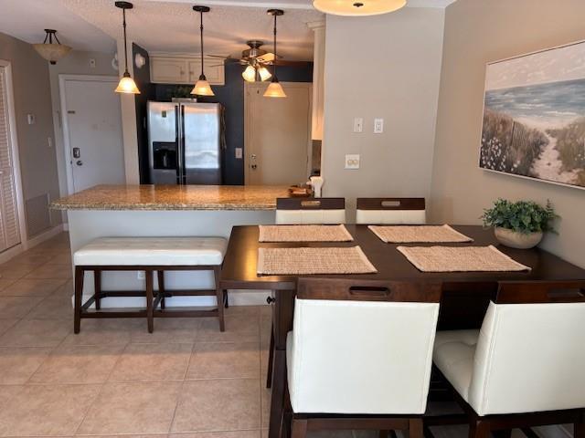 A dining area with a wooden table and chairs sits adjacent to a kitchen island — 133 N Pompano Beach Boulevard # 209, Pompano Beach FL 33062, POMPANO BEACH, FL