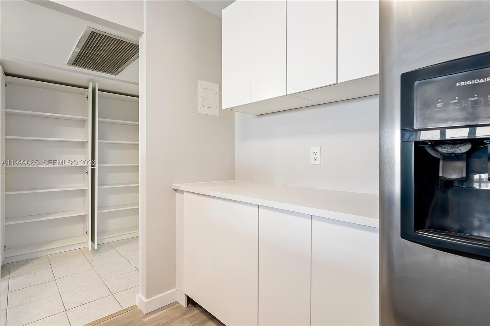 A kitchen area features white cabinets, a countertop, and an adjacent walk-in pantry — 701 Three Islands Blvd # 316, Hallandale Beach FL 33009, HALLANDALE BEACH, FL