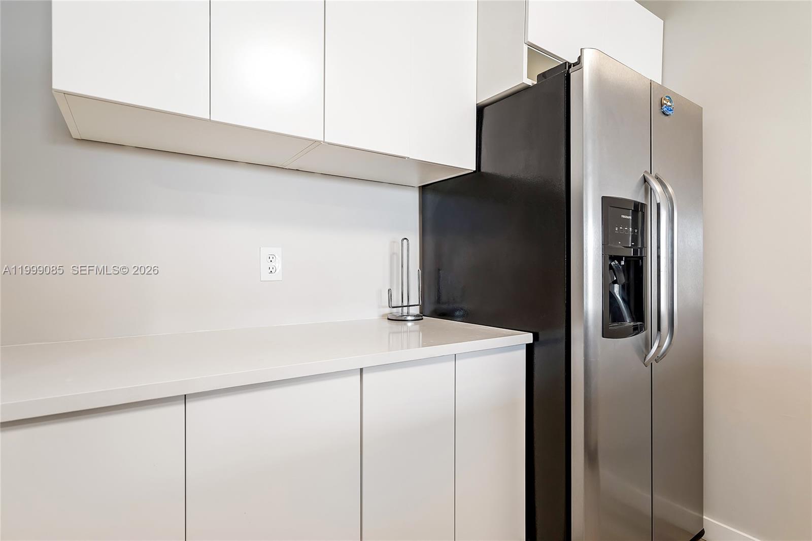 A kitchen features white flat-panel cabinets, a white countertop, and a stainless steel refrigerator — 701 Three Islands Blvd # 316, Hallandale Beach FL 33009, HALLANDALE BEACH, FL
