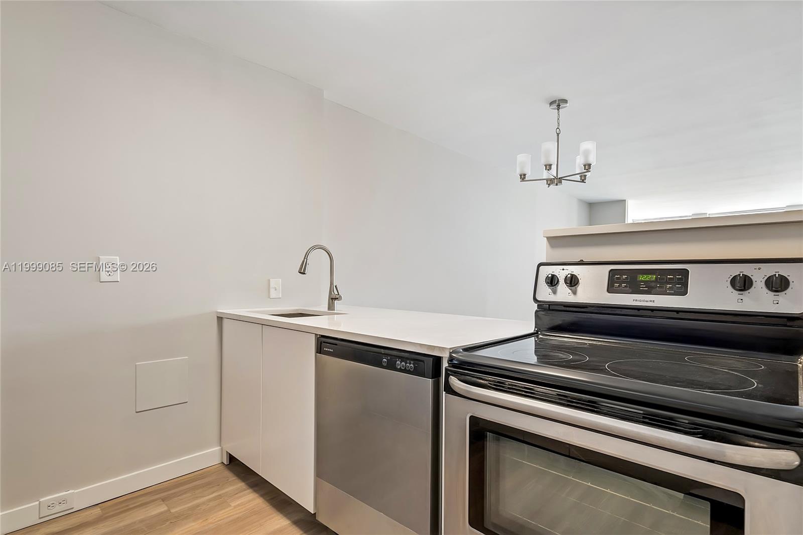 A kitchen features white cabinets, a stainless steel dishwasher, a stove, and a sink — 701 Three Islands Blvd # 316, Hallandale Beach FL 33009, HALLANDALE BEACH, FL