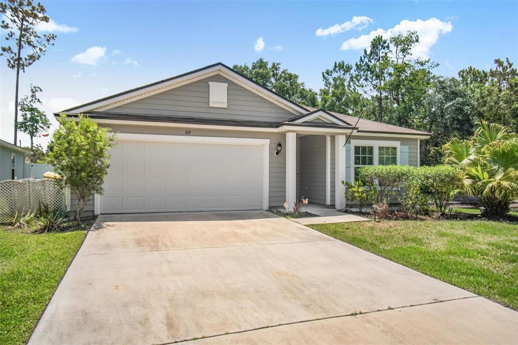 A single-story house with gray siding, a two-car garage, and a concrete driveway — 619 GRAND RESERVE DRIVE, BUNNELL, FL