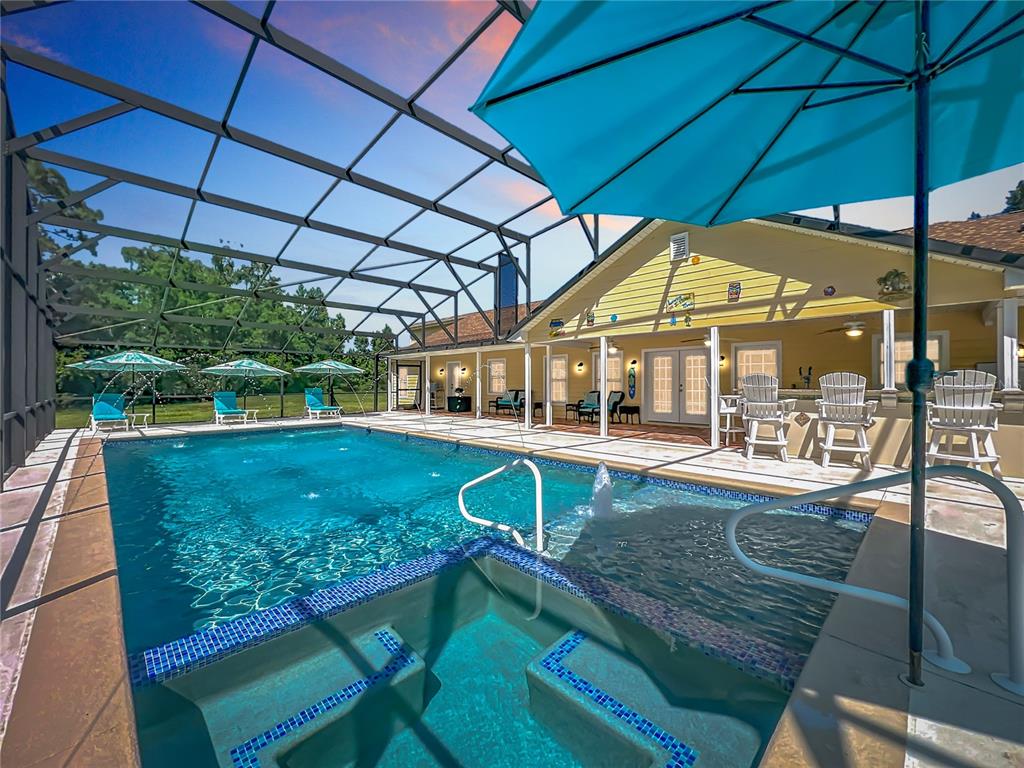 An aerial view shows a house with a pool surrounded by trees and open fields — 2300 PINE MEADOWS PLACE, CHULUOTA, FL